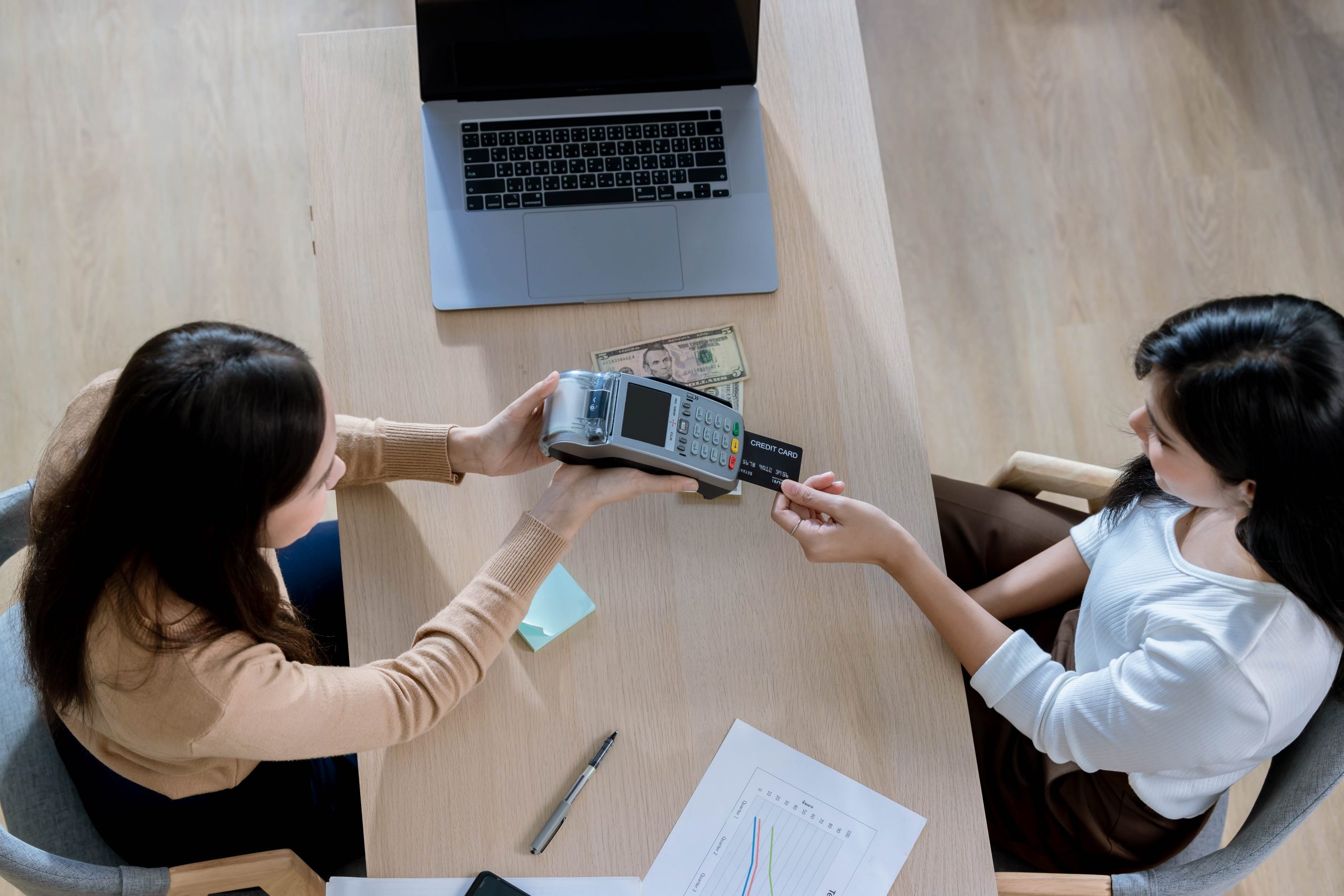 Customer using credit card for payment to receptionist. cashless technology and credit card payment concept. Owner In Retail Shop With Customer Paying Using Payment Credit Card